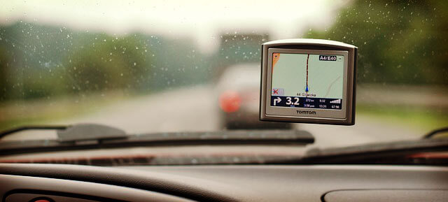 Imagen ilustrativa de la noticia con un GPS en el parabrisas delantero de un coche